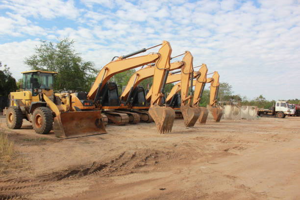 Big yellow excavator and other construction machinery in working space
